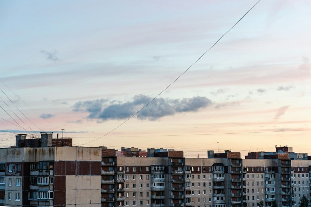 Apartment buildings with balconies under a pale orange and blue sky