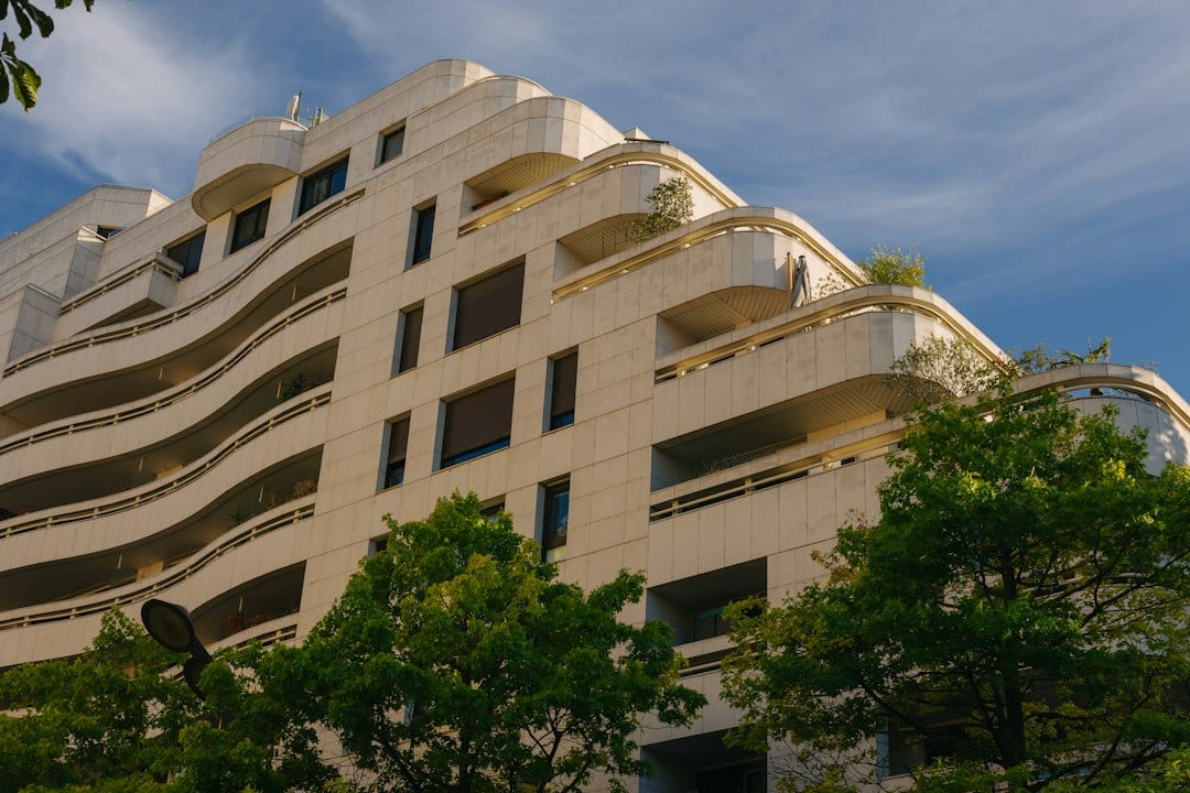 Modern condominium building exterior with curved balconies and stone cladding